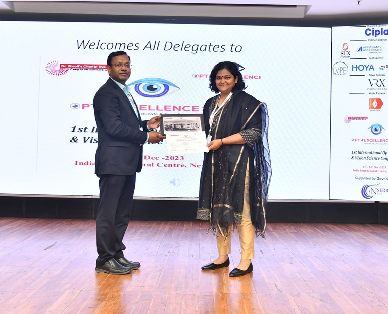 Raji receives plaque after keynote speech at OptoExcellence organized by Shroff's charity hospital, New Delhi, India